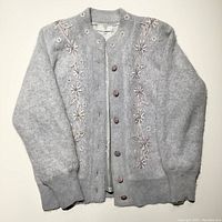 Front view of light silver grey angora wool sweater jacket with embroidered floral details, six button closure, ribbed cuffs and waistband
