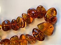 Close-up of polished amber nugget beads showing color variations and internal clarity