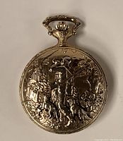 Front cover of gold embossed Lucerne pocket watch showing hunter and dogs motif in relief.