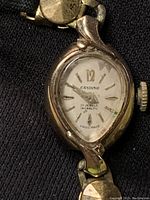 Close-up of watch face showing Candino brand, hour markers, and manual wind crown.