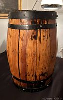 Side view of vintage oak barrel showing wood grain and galvanized iron hoops