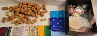 Photo of approximately 55 champagne and wine corks with some wine corks mixed in, placed beside bandanas and a box of beads.