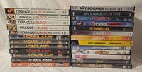 Photo of DVD cases stacked in two columns showing Homeland and Orange is the New Black seasons along with various movies and shows.