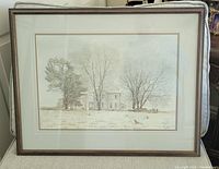 Framed art print of a farmhouse in winter with snow on the ground and leafless trees