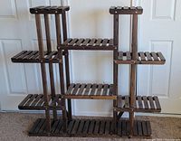 Full view of the multi-tier wooden plant stand showing the various shelf levels and overall structure.