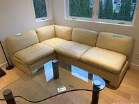 Overall view of the L-shaped beige leather sectional in room