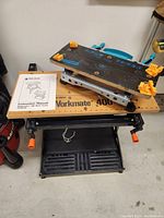 Front angle view of Black & Decker Workmate 400 work center with Wolfcraft scale work station mounted on top and instruction manual placed on the work surface.