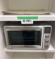 DeLonghi toaster oven and stacked placemats on shelf
