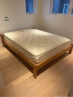 Full view of oak wood bed frame with mattress