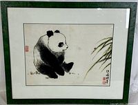 Full view of framed watercolor painting depicting a panda bear sitting near bamboo leaves, signed and sealed, under glass in green frame.