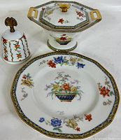 Full view of all three porcelain items: bell, sugar bowl, and plate with floral decoration and gold trim.