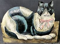 Full side view of the tin tole metal cat planter box showing painted fur pattern, pink bow, and base.