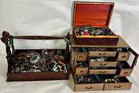 Two wooden jewelry boxes filled with assorted jewelry items displayed side by side