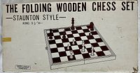 Box lid showing the printed text 'THE FOLDING WOODEN CHESS SET - STAUNTON STYLE - KING 3 1/4" H' with an illustration of the chessboard and pieces.