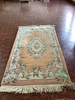 Full view of the wool area rug placed on a patterned floor, showing the design and condition.