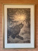 Front view of framed artist print showing owl perched on branch among pine foliage with glare-resistant glass.