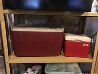 Both coolers placed side by side on a shelf, showing size comparison and exterior condition.