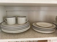 Royal Doulton Lambeth stoneware dishes including mugs and plates with brown edging and decorative embossing.