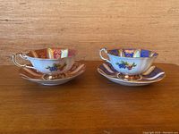 Two Paragon single warrant teacups with matching saucers side by side showing contrasting pink and blue backgrounds with floral and gold decoration.
