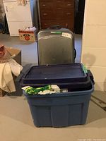 Blue plastic tote with 'Tucker Tote Roughneck' label on lid close-up.