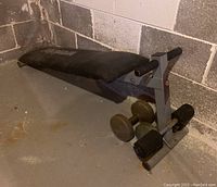 Side view of Weider weight bench showing padded black seat with Weider branding and leg holders