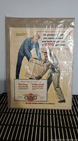 Front view of the vintage GWG advertisement featuring two men with boxes and promotional text about the garment's durability.