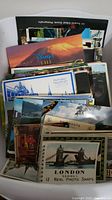 Collection of old postcards stacked together showing a variety of locations and themes.