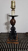 Full view of vintage table lamp showing the black ornate base, brown spherical center, and metal socket with bulb holder on top.