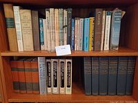 Books on shelf including Ian Fleming James Bond, Carl Sandburg Lincoln Series, Winston Churchill History of the English Speaking Peoples, and other classic titles.