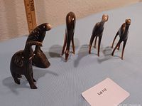 Angle showing six carved stone animal figurines including elephant with chipped tusk and perched bird figurine.