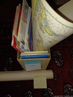 Box with rolled and folded maps including National Geographic and military maps visible