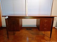 Front view of desk showing overall form, drawer configuration, finish.