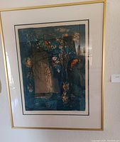 Framed lithograph showing a dark vase of flowers with orange accents, signed Lebadang, hung on wall.