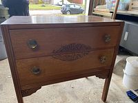 Photo showing front view of the solid oak vanity with drawer details and legs.