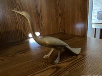 Brass long-necked bird figurine, side angle showing body and head details