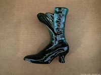 Front angled view of Black high heel shoe ceramic figurine showing detailed lacing and heel