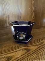 Small cobalt blue vase with stand, showcasing hexagonal shape with floral and peacock design