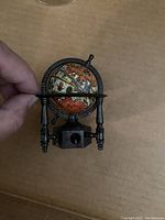 Close-up photo of the globe pencil sharpener showing the detailed world map and antique finish.