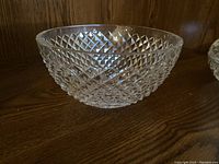 Large clear glass bowl with diamond pattern texture, shown against a wooden background.