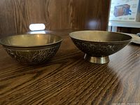 Two brass bowls on wooden surface, showing general size and shape difference