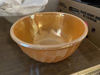 Glass peach colored serving bowl with a swirled pattern, vertical grooves on exterior, smooth interior, approximately 7 inches diameter.