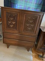 Front view of the dresser showing two decorative carved doors over two lower drawers