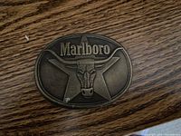 Oval Marlboro belt buckle with a longhorn skull and star background