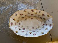 Oval serving bowl with scattered pansy flowers and gold rim.