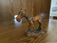 Front view of the small horse carving figurine made of wood or composite material, showing ribs clearly and painted brown with black tail and mane.