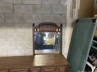 Full view of dresser and large mirror showing wood tone and design.