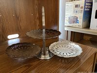 Photo showing the 3-level folding serving tray with three oval-shaped trays, metal with floral cut-out decoration.
