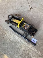 Side view of the Black Jack 2 ton car jack with handle showing overall appearance and condition on ground.