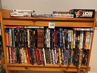 Wide view of wooden shelf full of assorted DVDs showcasing variety and quantity