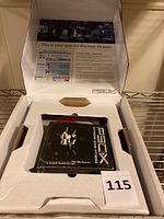 View of the open white cardboard package with the black P90X Workout DVD case inside, showing front cover art with muscular figures and title.